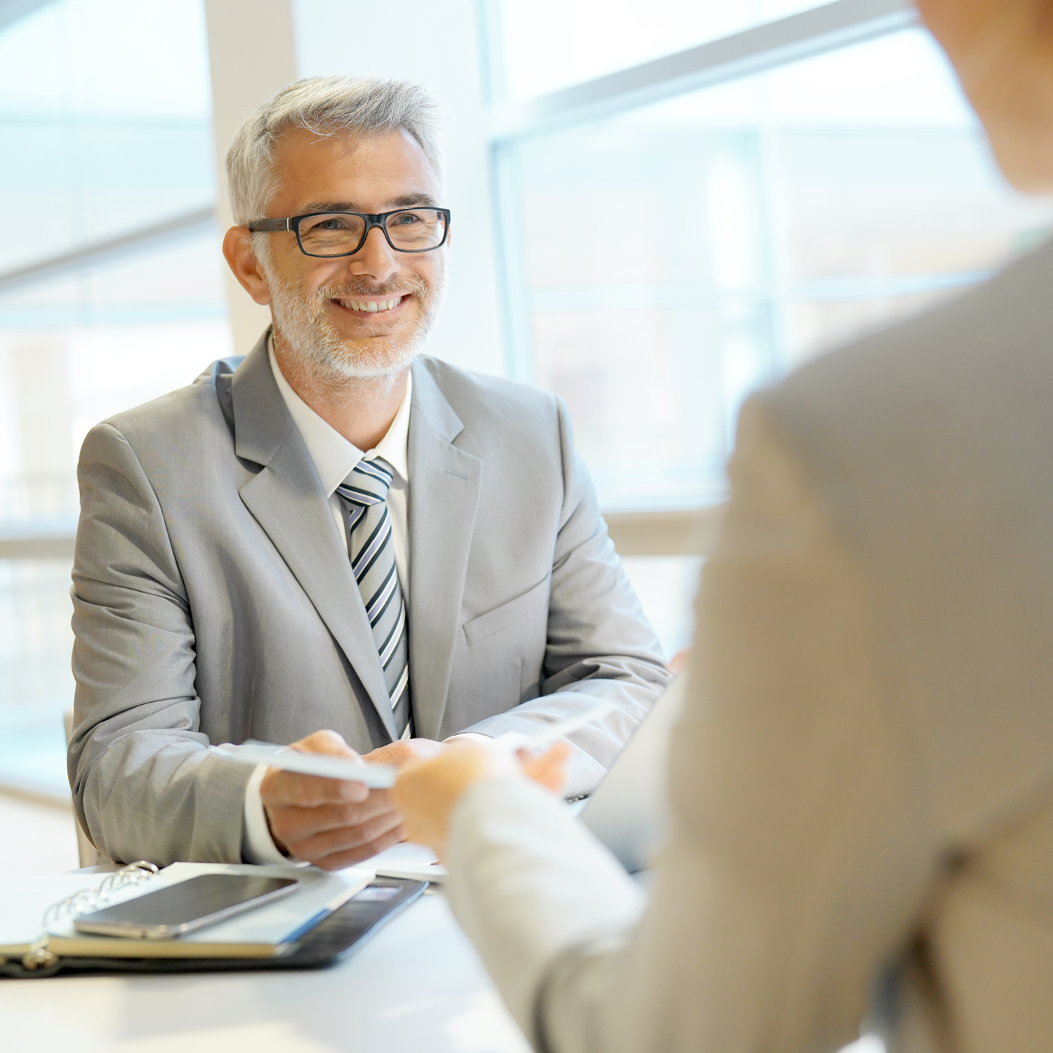 man handing papers to another person
