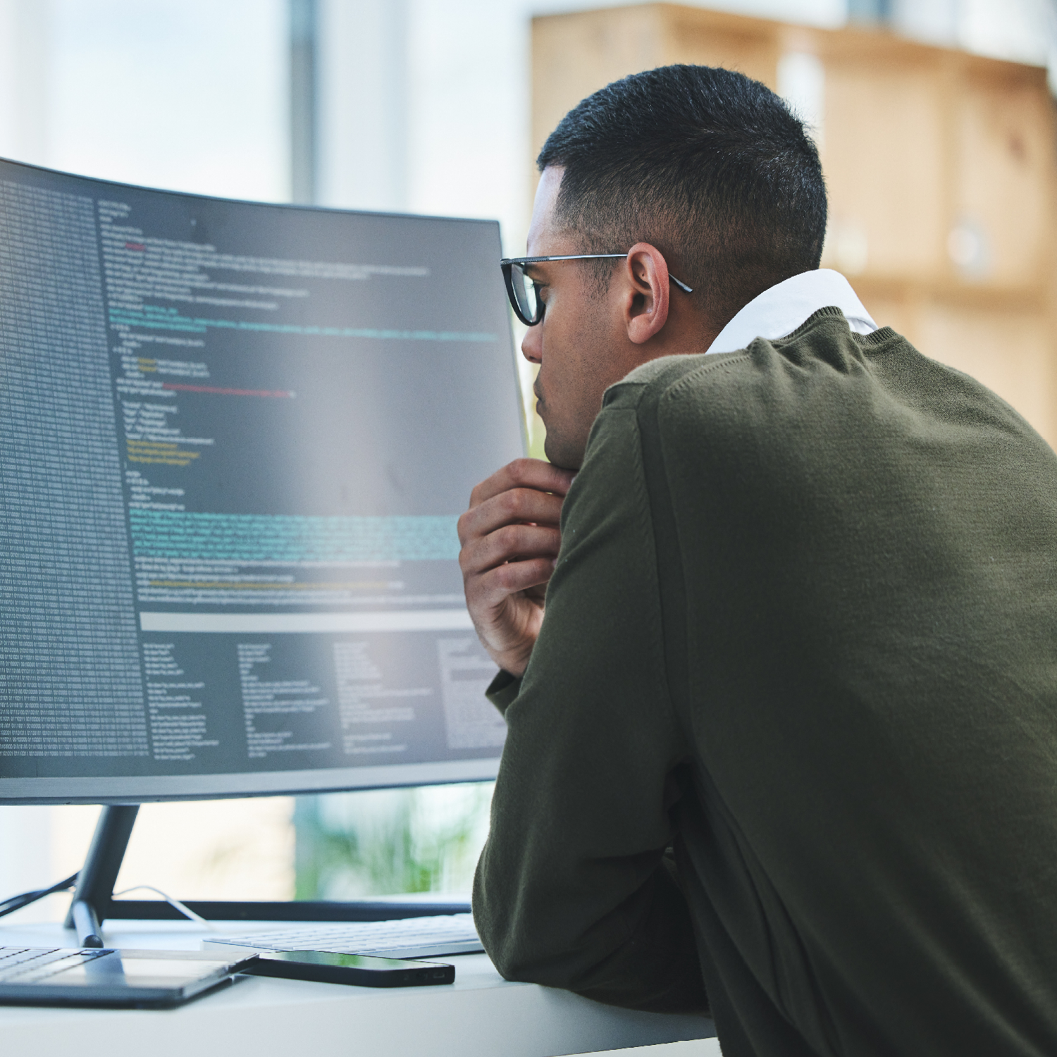 Man looking at code on a computer screen