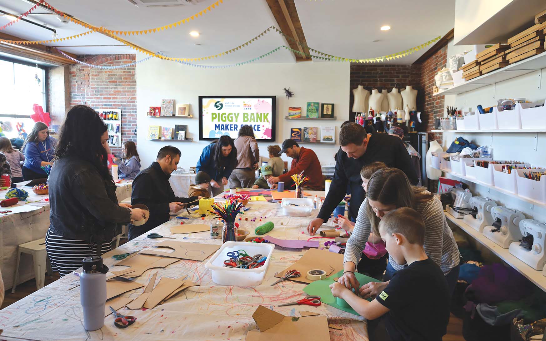 Families work together to build piggy banks at Mill Studio Arts. | Photo courtesy of Saco & Biddeford Savings