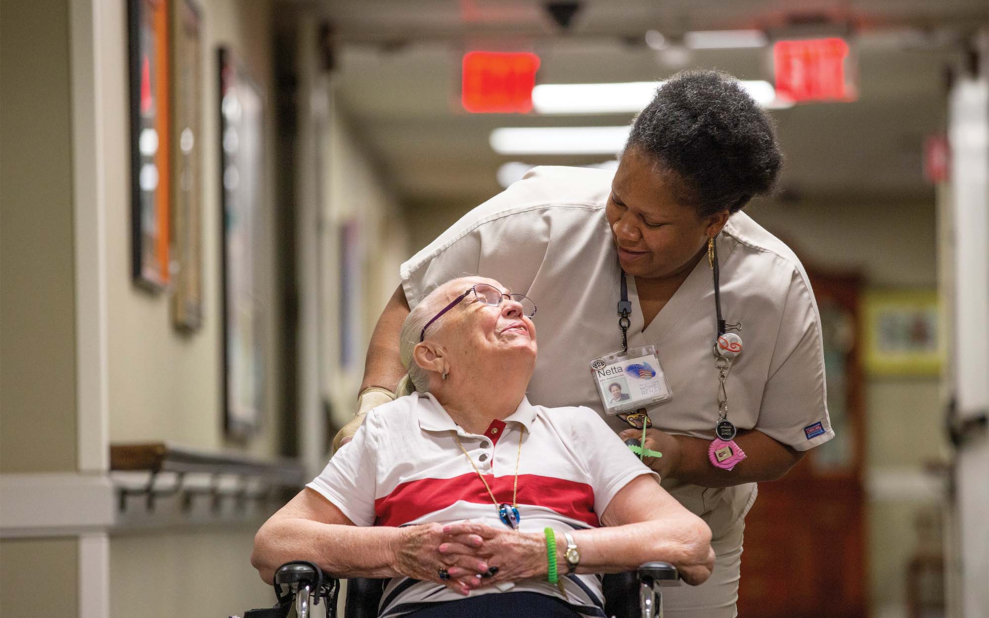 Woman pushing another woman in a wheelchair