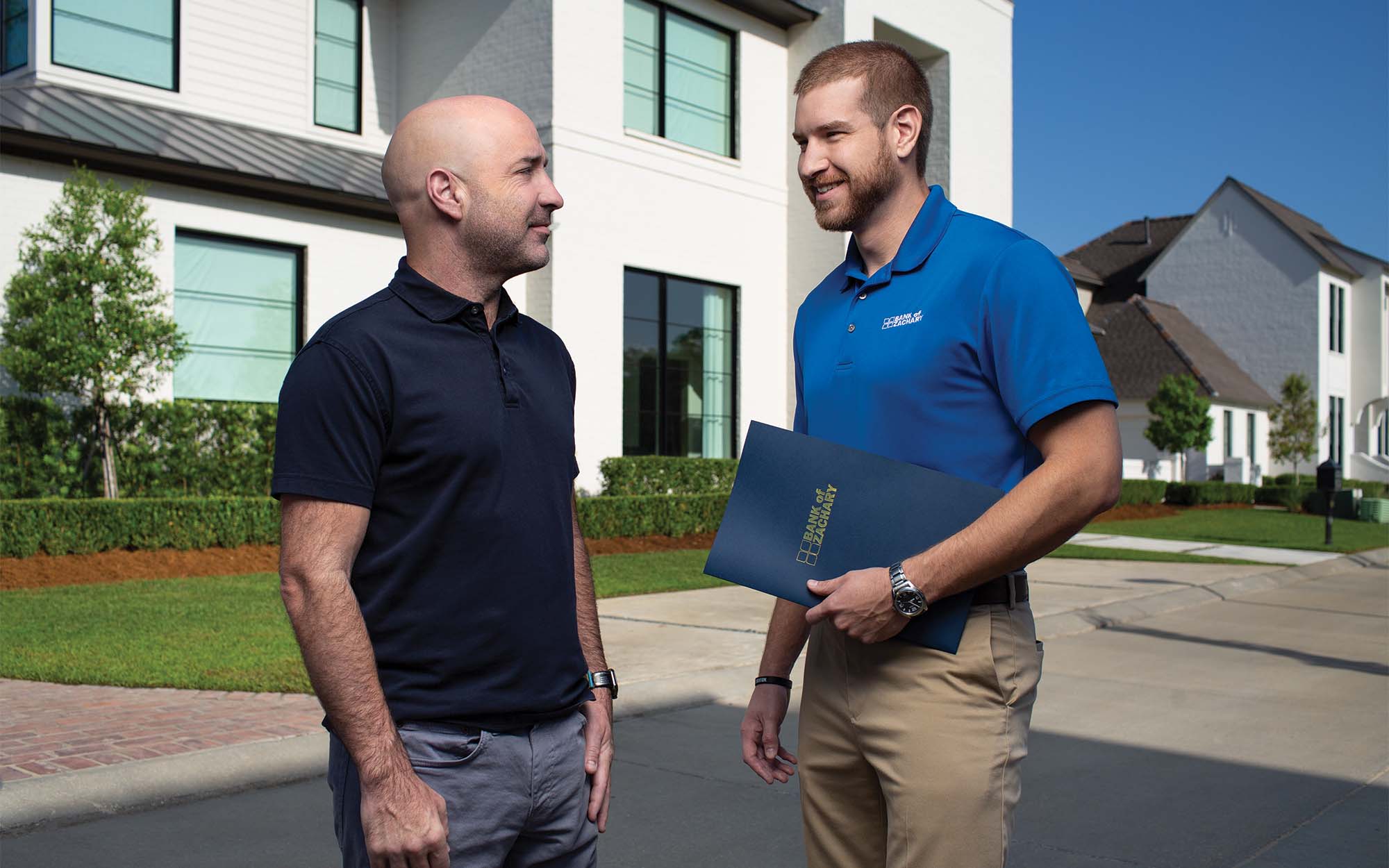 Josh Prejean (right) of Bank of Zachary, with mortgage client David Rozas