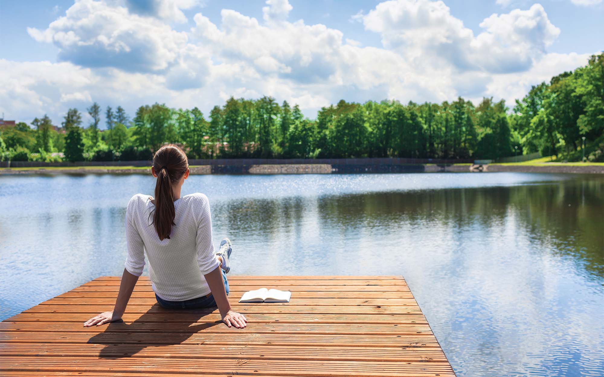 woman sitting on a dock on a lake