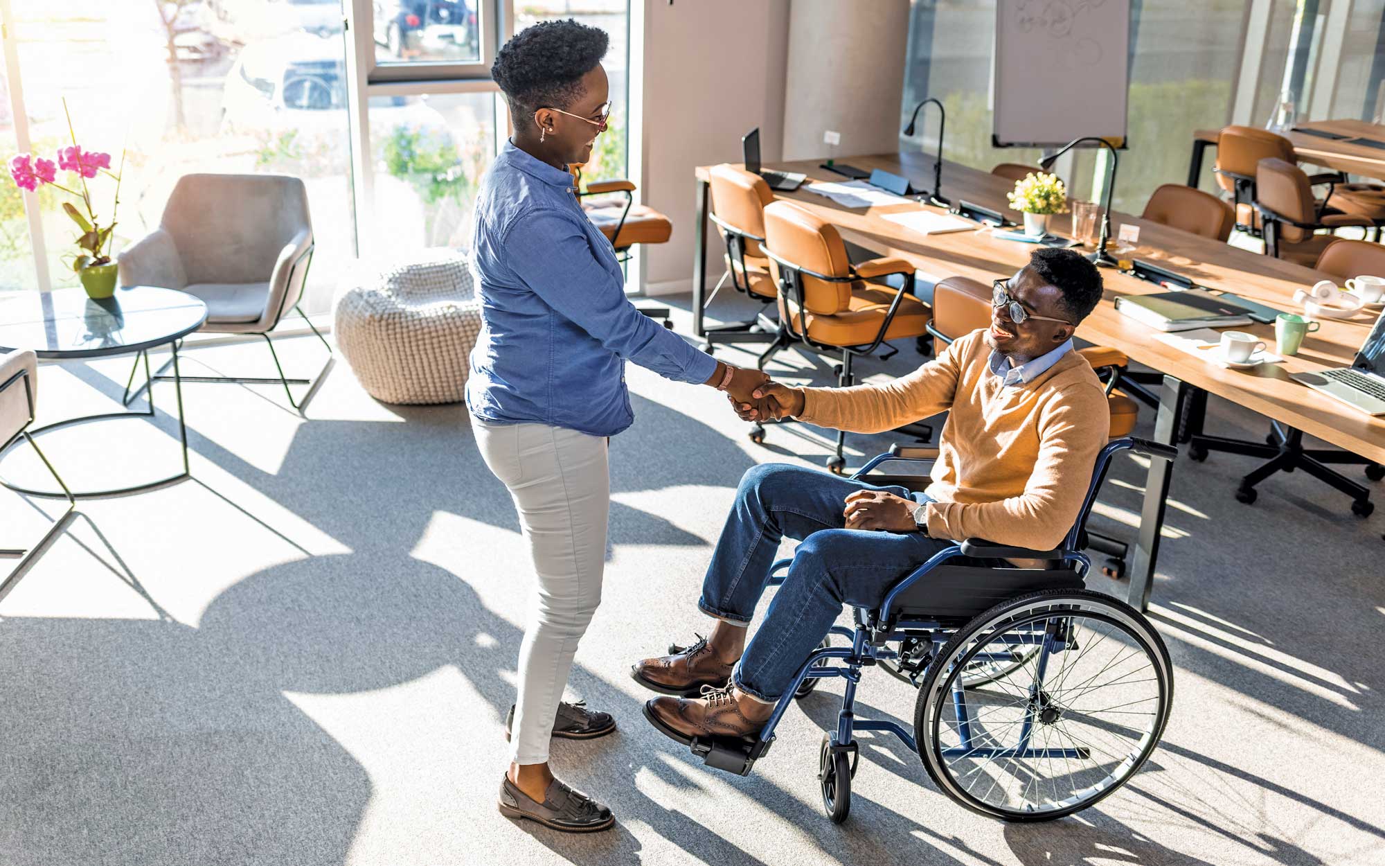 Woman shaking hands with man in wheelchair