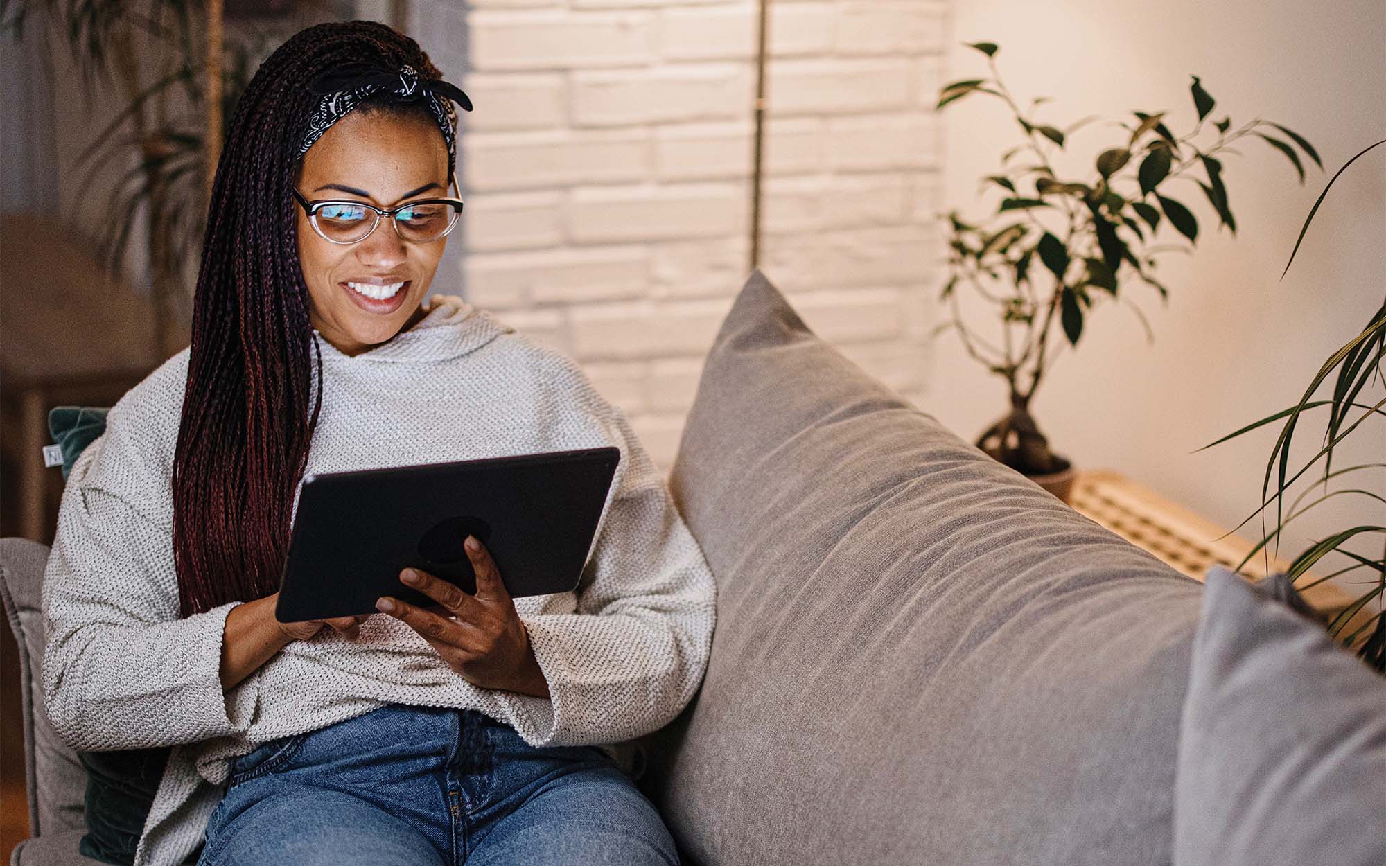 woman on couch using tablet